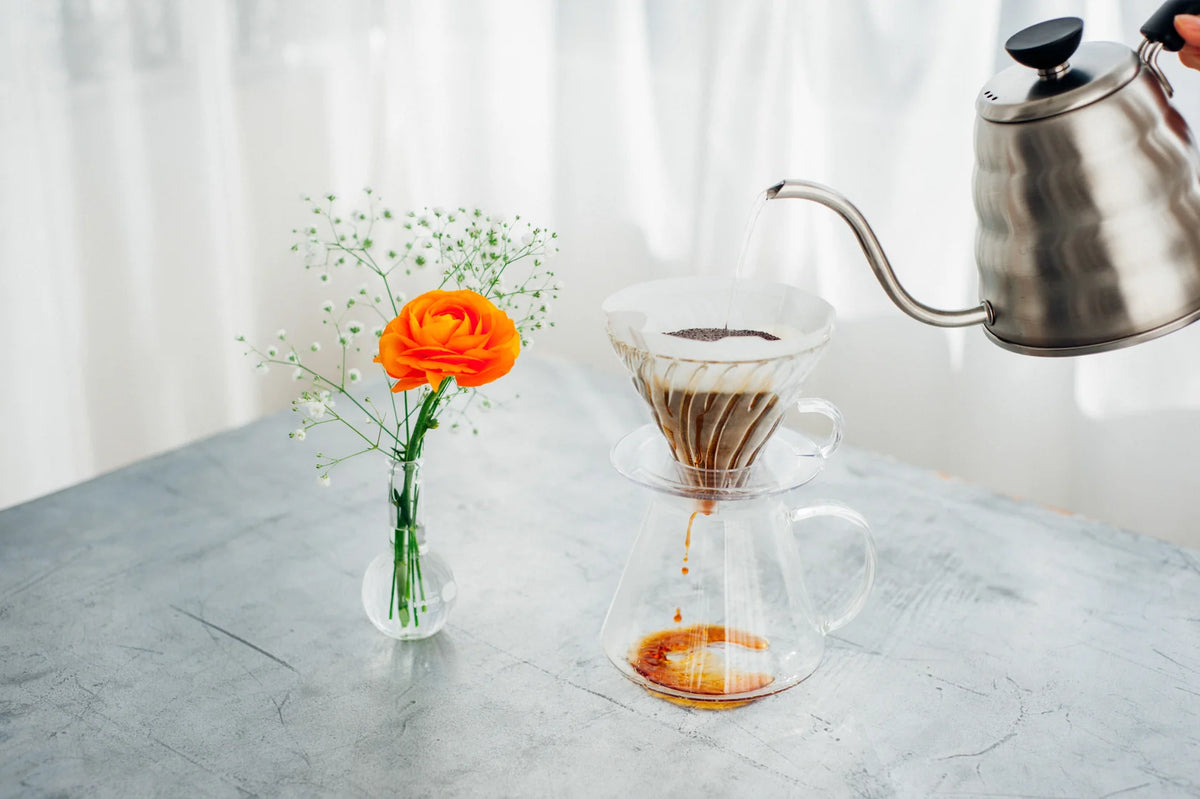 Pour-over coffee brewing in the glass Hario V60 kit